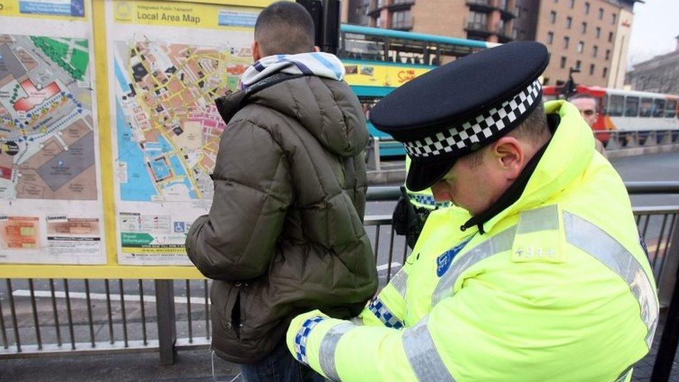 A man being searched by a police officer