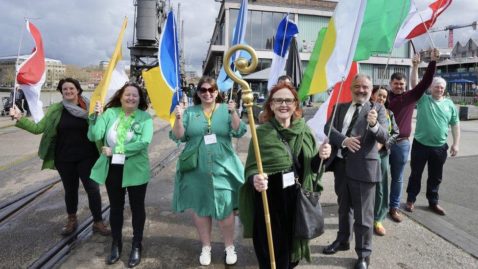 People holding flags at the start of the Bristol St Patrick's Day Parad