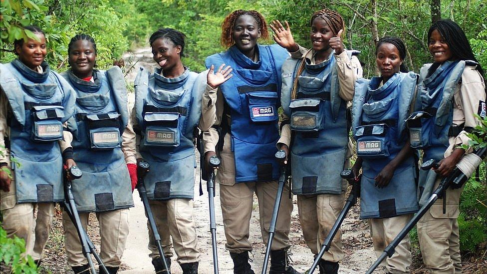 A picture showing women de-miners in Angola waving to the camera