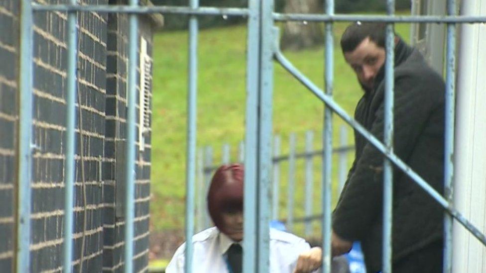 Jason Liam Cooper being led into Mold Crown Court