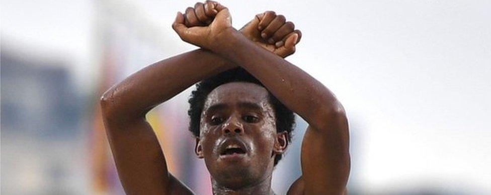 Ethiopia's Feyisa Lilesa crossed his arms above his head at the finish line of the Men"s Marathon athletics event of the Rio 2016 Olympic Games at the Sambodromo in Rio de Janeiro on August 21, 2016.