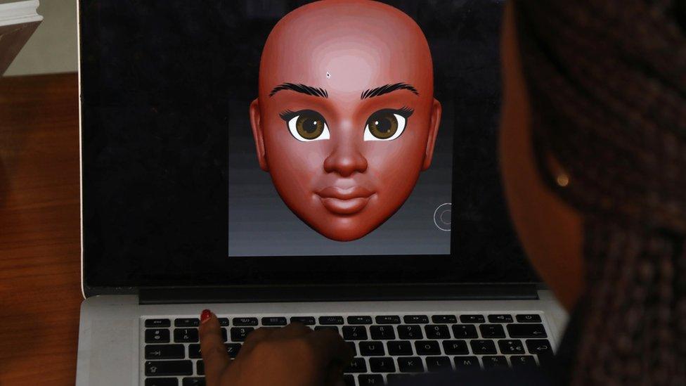 a woman at a computer designs the features of a Naima doll