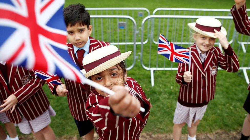 School children in uniform wave Union Flags outside Windsor Castle ahead of Britain's Prince Harry and Meghan Markel's wedding, in Windsor