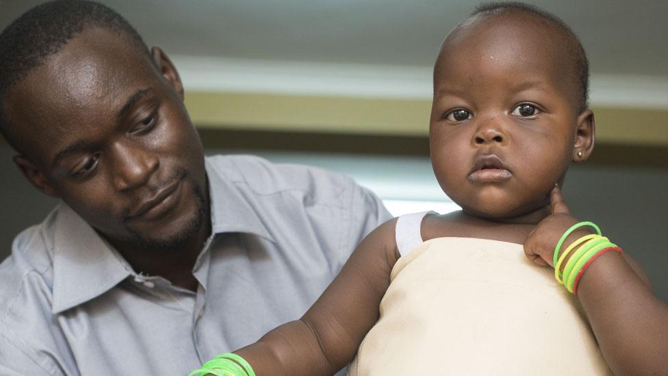 Brian Turyabagye and baby wearing a jacket which detects pneumonia