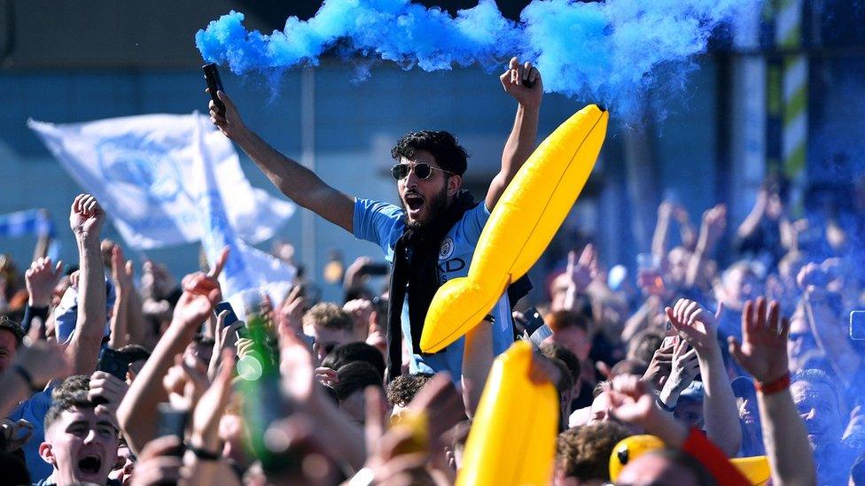 Man City fans celebrate and let off blue flare