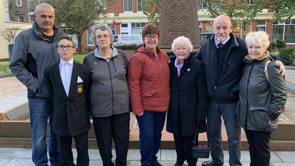 Family members in front of war memorial