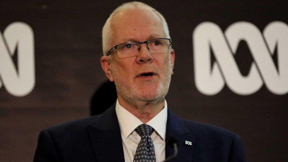 Justin Milne in front of an ABC logo