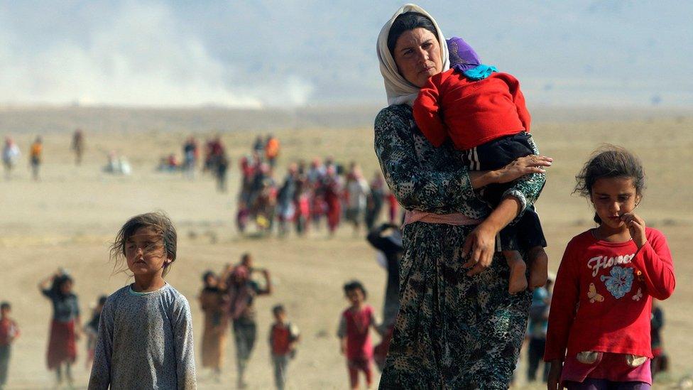 Displaced Yazidis fleeing Islamic State militants in Sinjar, Iraq, walk towards the Syrian border (11 August 2014)