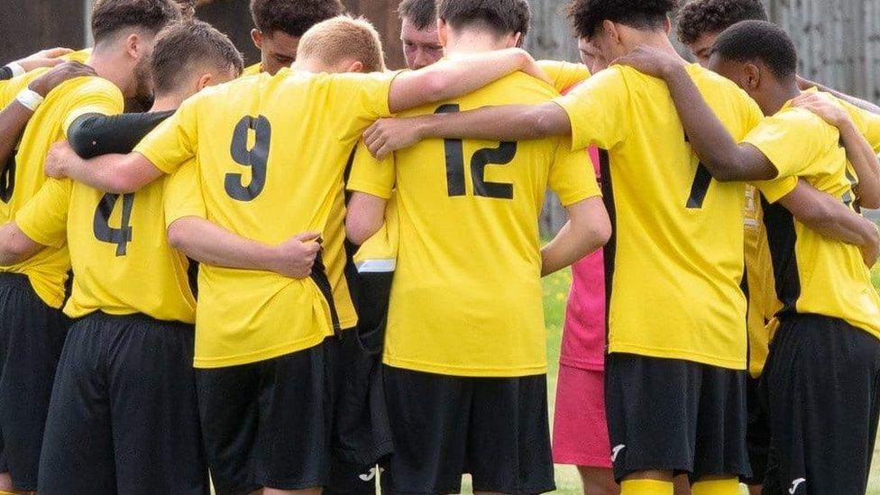 The team huddled together in their yellow strips.