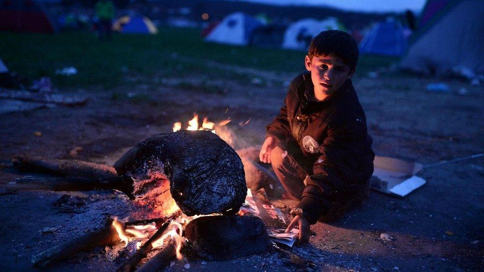 Refugee child at bonfire in makeshift camp at the Greek-Macedonian border near village of Idomeni, on March 3, 2016