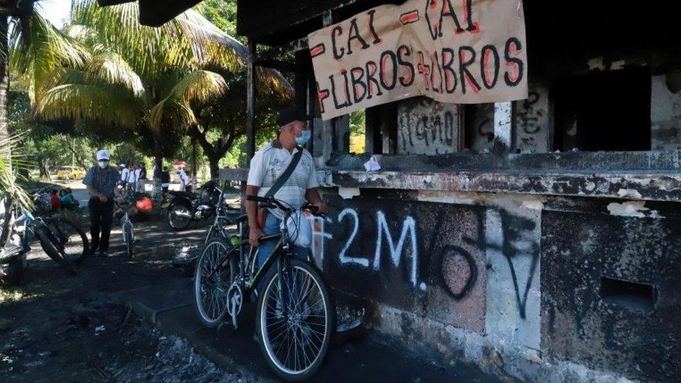 A man looks at a police station burned down during the protests against what they demonstrators say was police brutality exerted in recent protests against President Ivan Duque"s government"s tax reform in Cali, Colombia May 3, 2021.