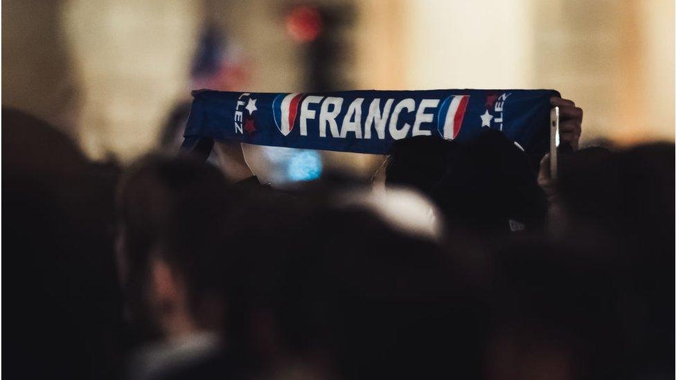 A person holds up a France scarf