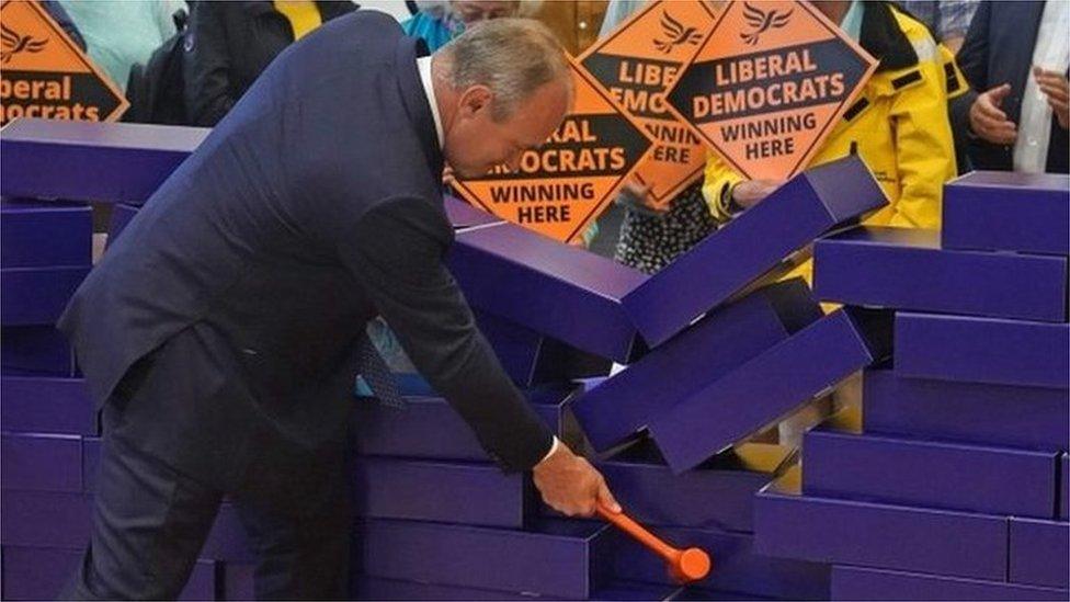 Ed Davey knocks over blue wall, June