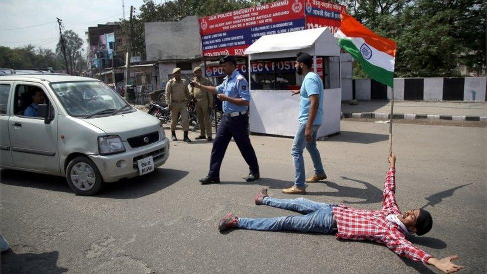 An Indian student holds Indian flag and blocks road as he shout slogans against the alleged police action on outstation students at the National Institute of Technology (NIT) Srinagar during protest demonstration in Jammu.