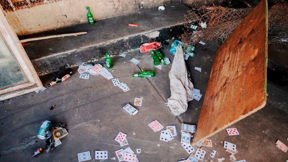 Cards and beer bottles lie on the floor of an informal gambling spot after South African Police Service (SAPS) arrested 8 people because they defied the lockdown rules and the alcohol restriction in Hillbrow, Johannesburg, on March 27, 2020.