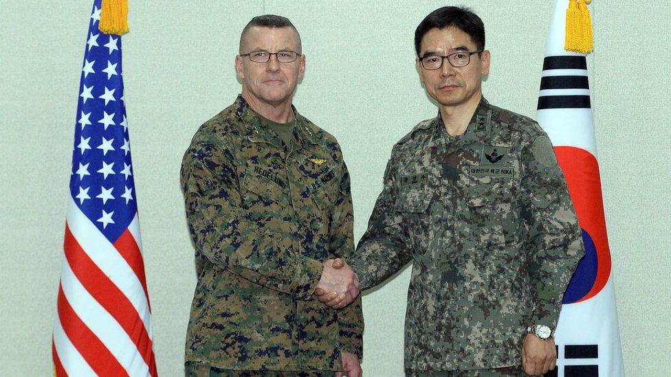 South Korea's Major General Jang Kyung-soo (R) and US Forces Korea Major General Robert Hedelund shake hands at the Defense Ministry in Seoul