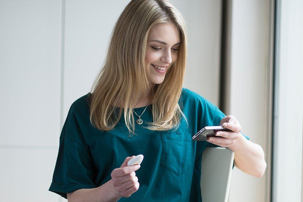 Woman holding Pip gadget and phone