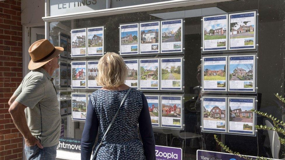 Couple looking at estate agent window