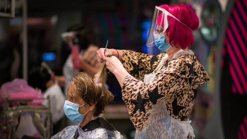 Hairdresser Carole Rickaby cuts her client Sandra Jacobs' hair shortly after midnight on Saturday