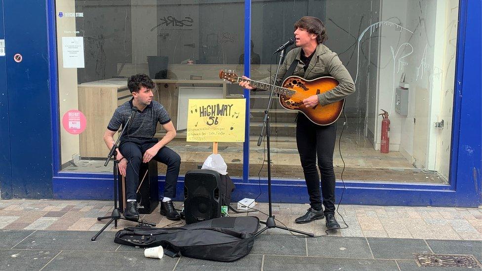 Busking duo Fergus and Cormac perform with a guitar and drums in Belfast