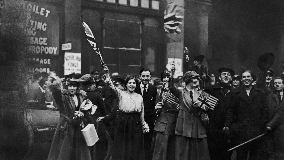 Soldiers and civilians celebrate Armistice Day on 11 November 1918