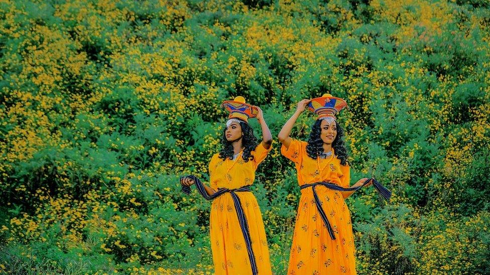 Women standing in front of some bushes