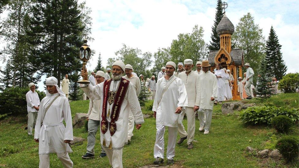 Followers of the Church of the Last Testament religious movement walk after a religious service