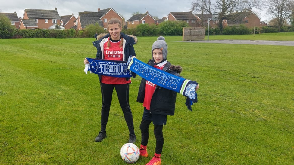 Emilia, 13, and Jakub, 8, holding Peterborough United scarves