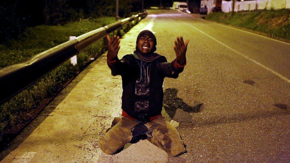 An African migrant celebrates on a road after crossing the border fence between Morocco and Spain's north African enclave of Ceuta, 9 December 2016