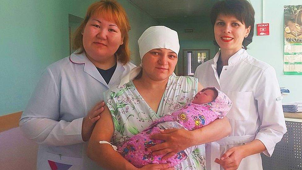 Alexandra Matrosova and her baby with doctors at the hospital