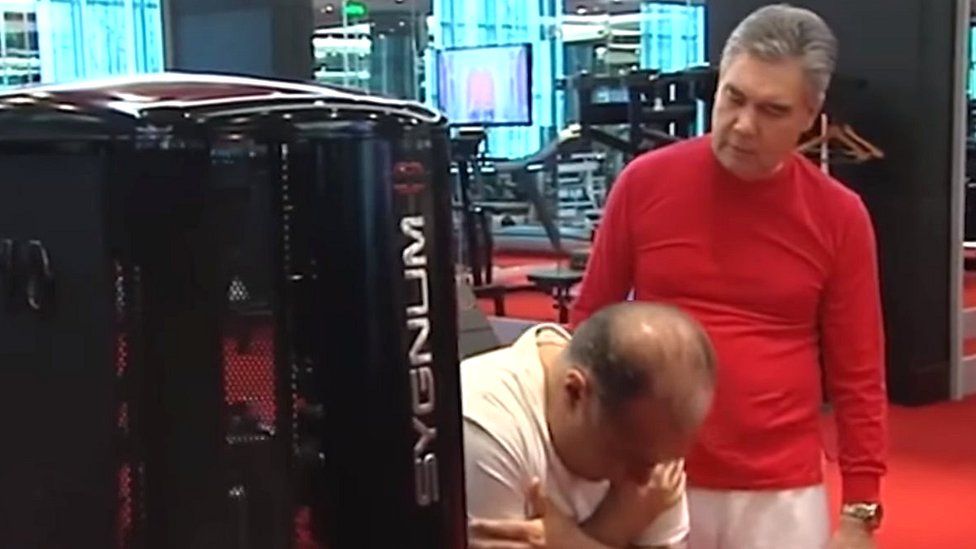 Turkmen President Gurbanguly Berdimuhamedov teaches a state official how to use an exercise machine