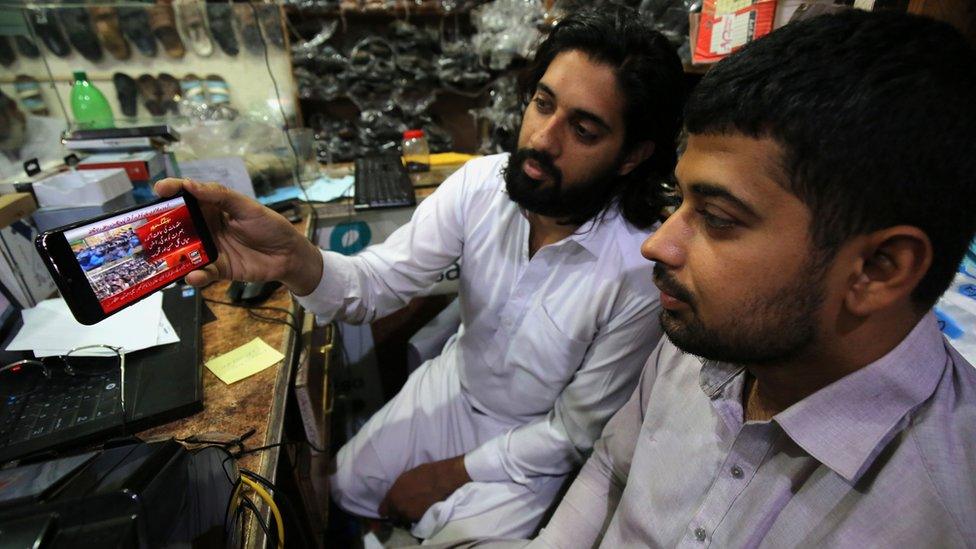 People in Peshawar watch the news of Mr Khan being granted bail at Islamabad High Court