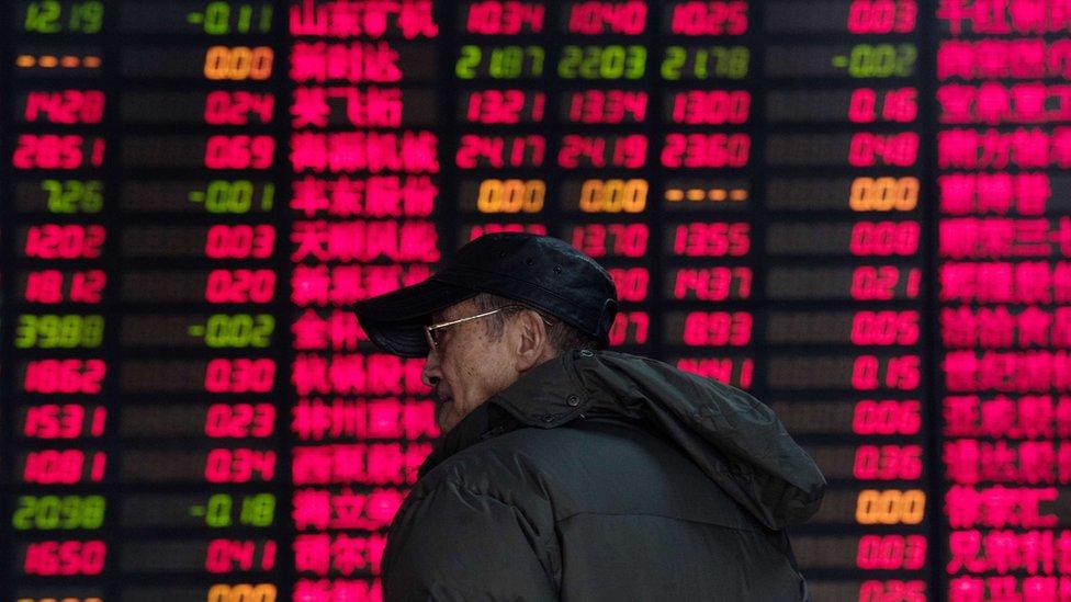 In a photo taken in December 2015, an investor monitors screens showing stock market movements at a brokerage house in Shanghai