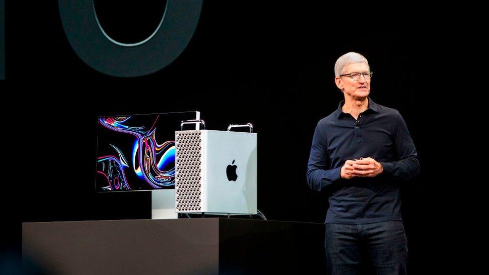 Apple's CEO Tim Cook stands next to the latest Mac Pro and monitor combo on stage at WWDC 2019