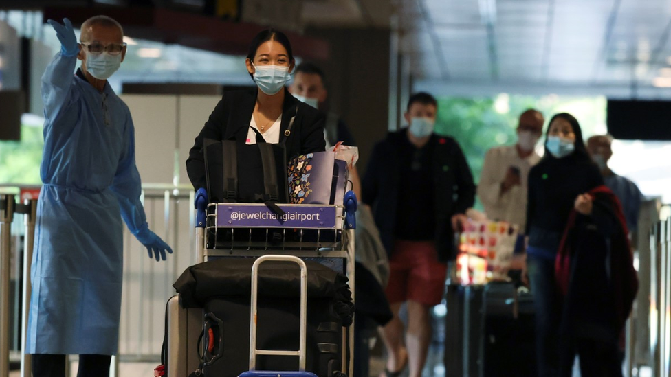 Travellers wearing masks arrive at Singapore Airport