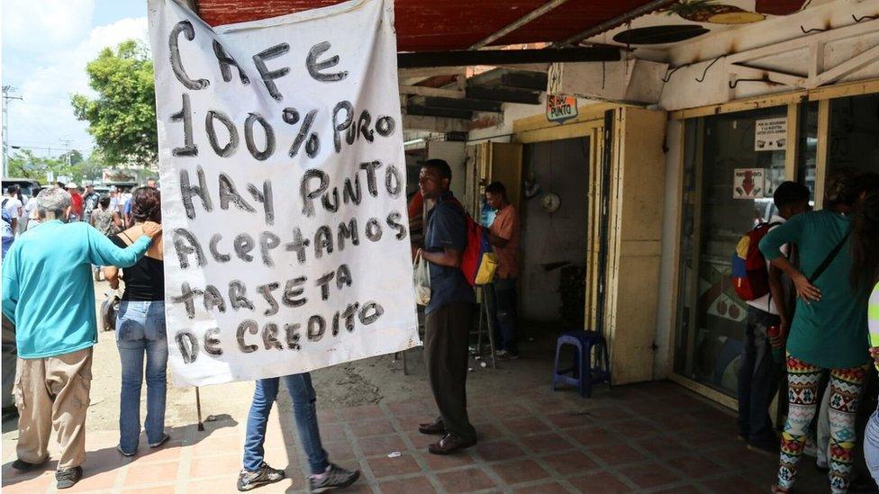 A sign advertising coffee says that the seller accepts credit cards