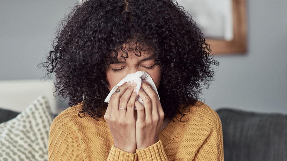 Woman blowing her nose (posed by model)