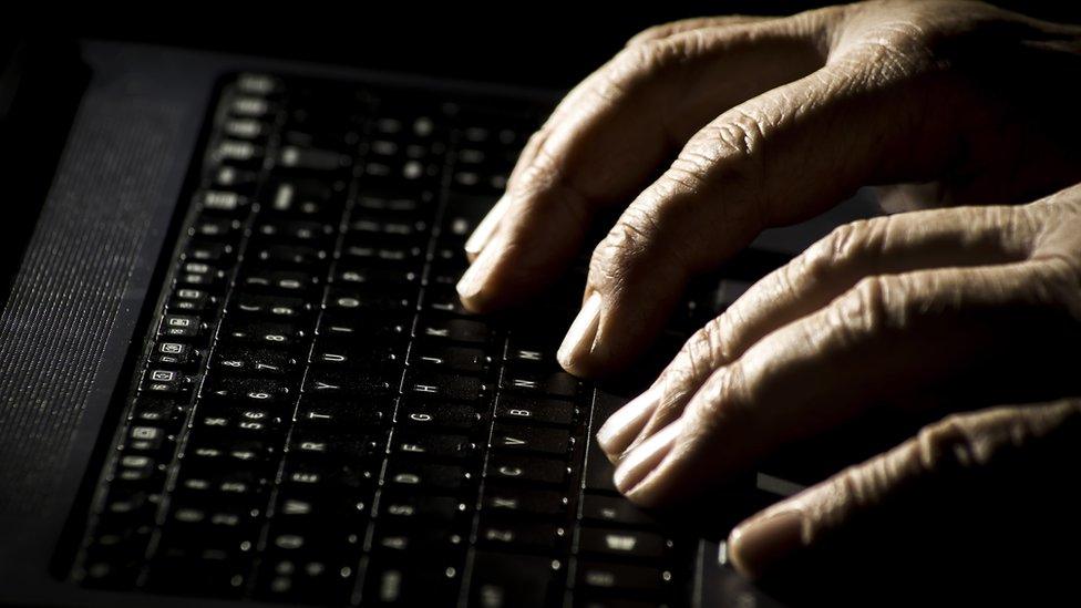 A person's hands on a laptop keyboard