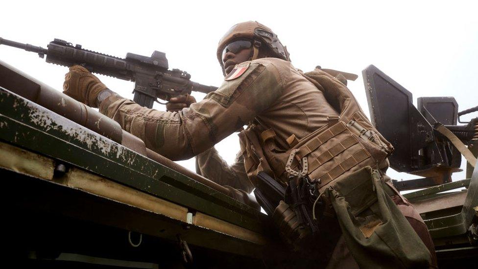 A soldier of the French Army aims at a man, suspected to be affiliated with jihadists, hidden in a forest frequented by jihadist groups, during the Bourgou IV operation in northern Burkina Faso