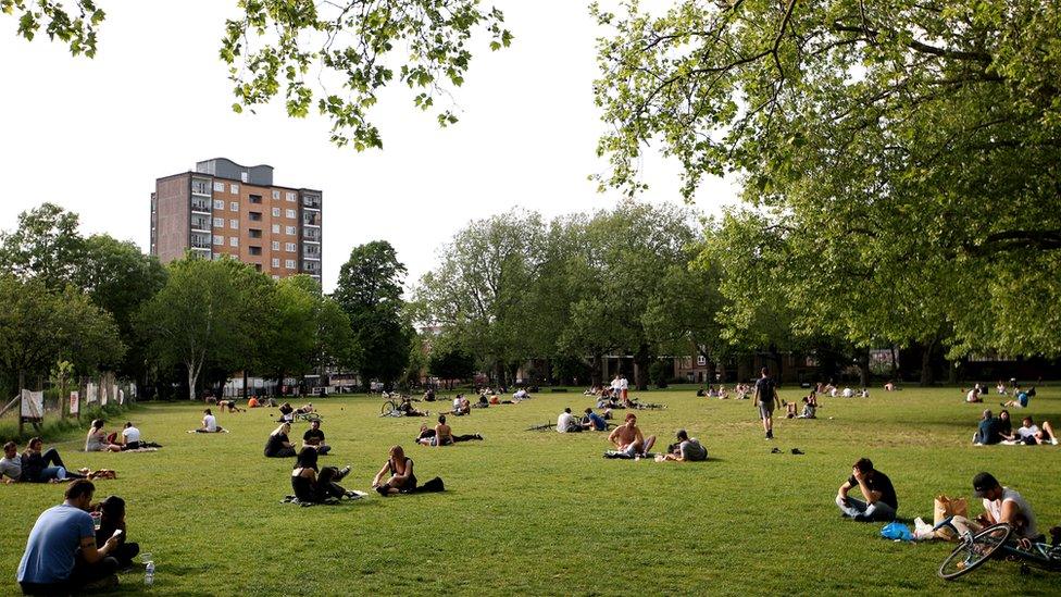 People sit in a park in London