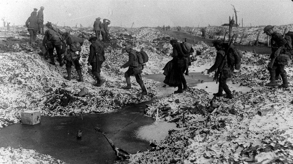 British soldiers crossing a shell-cratered, cold landscape along the River Somme