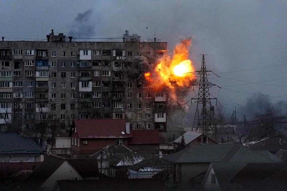 An explosion is seen in an apartment building after Russian's army tank fires in Mariupol, Ukraine, Friday, March 11, 2022.