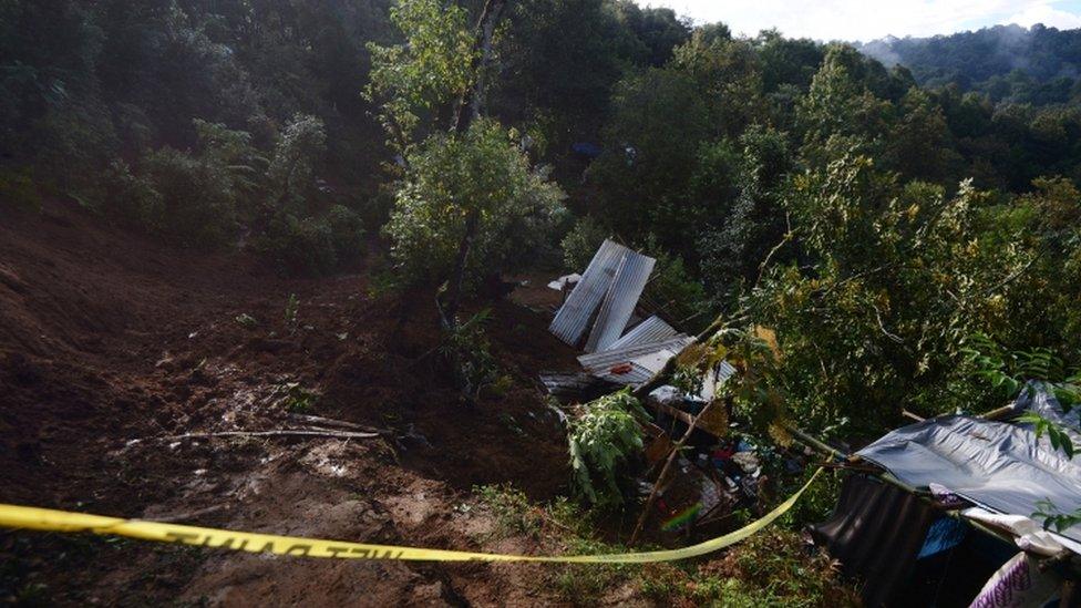 A police tape ropes off area where people died in mudslide