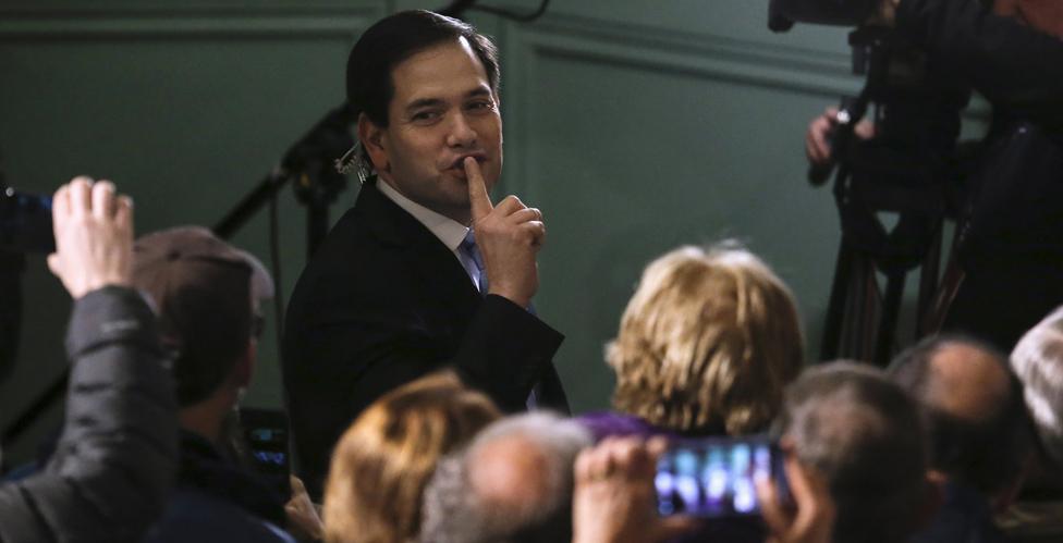 Republican presidential candidate Marco Rubio asks his supporters to be quiet as he attempts to conduct a TV interview before a campaign rally in New Hampshire