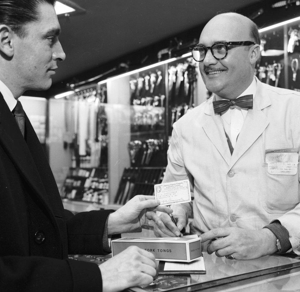 A customer pays with an American Express card in a cutlery shop in Manhattan, circa 1955