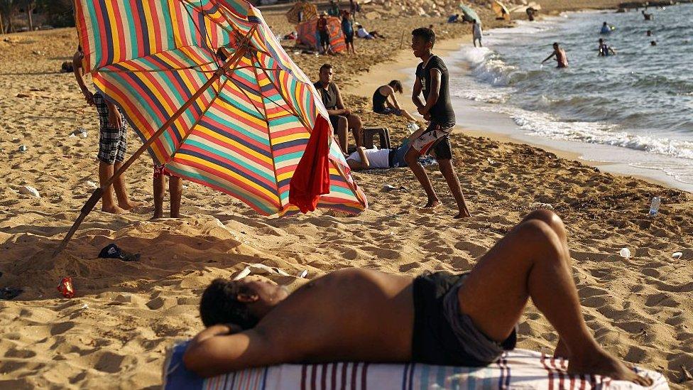 Libyans rest and swim at a beach in the eastern coastal Libyan city of Benghazi