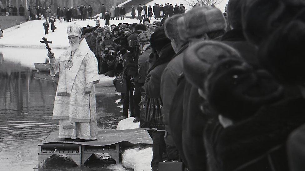 A priest blesses the Dnipro River