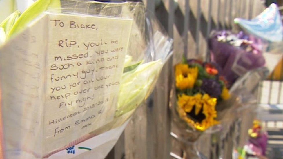 Flowers and messages pinned to gates at school