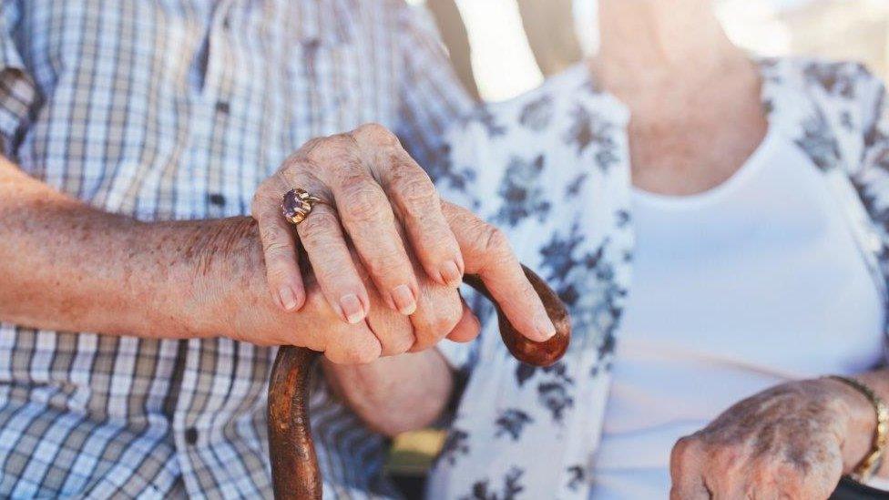 Close up old couple hold hands