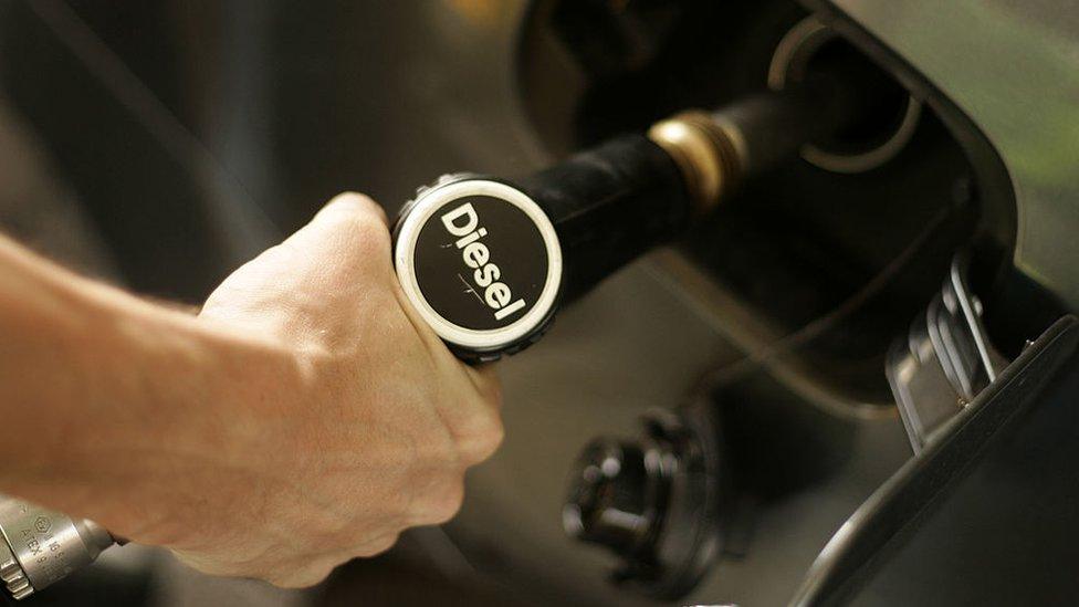 A driver fills his car with diesel fuel